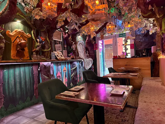 Interior de Serendipia La Caza Endulzada, restaurante de moda en Madrid centro, con decoraci&oacute;n fantasiosa, flores, luces y ambiente dulce en la Calle de San Bartolom&eacute; 21.