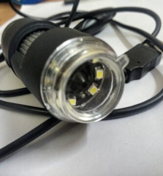microscopio digital USB con cámara y luces LED sobre una mesa de trabajo
