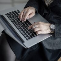 Persona escribiendo en un portátil, ilustrando el uso de un asistente de inteligencia artificial gratuito como Microsoft Copilot
