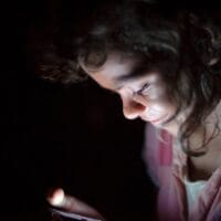 Persona usando el modo de voz de ChatGPT en el móvil de noche