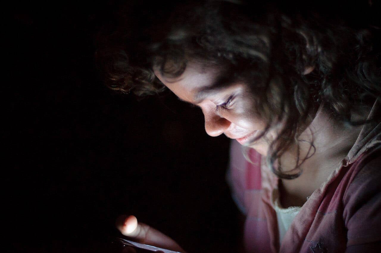 Persona usando el modo de voz de ChatGPT en el m&oacute;vil de noche