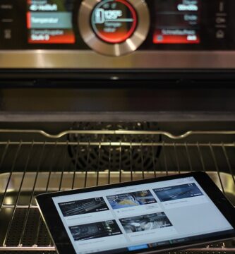 Interior de un horno eléctrico abierto con el panel de control encendido