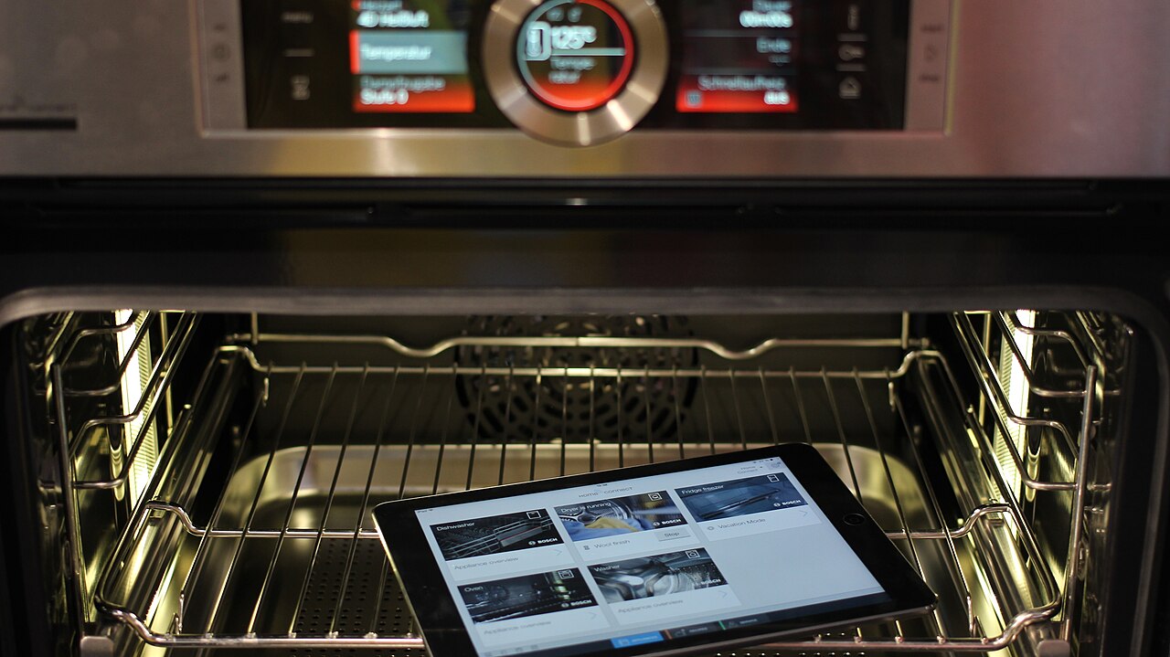 Interior de un horno el&eacute;ctrico abierto con el panel de control encendido
