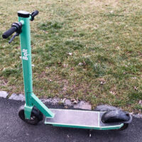 Patinete eléctrico plegado aparcado en la calle, visto de perfil