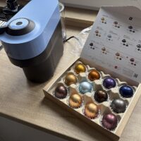 Cafetera Nespresso colocada en la encimera de una cocina junto a una caja de cápsulas