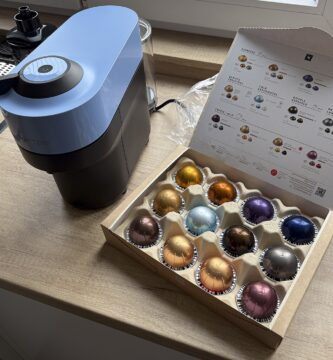 Cafetera Nespresso colocada en la encimera de una cocina junto a una caja de cápsulas