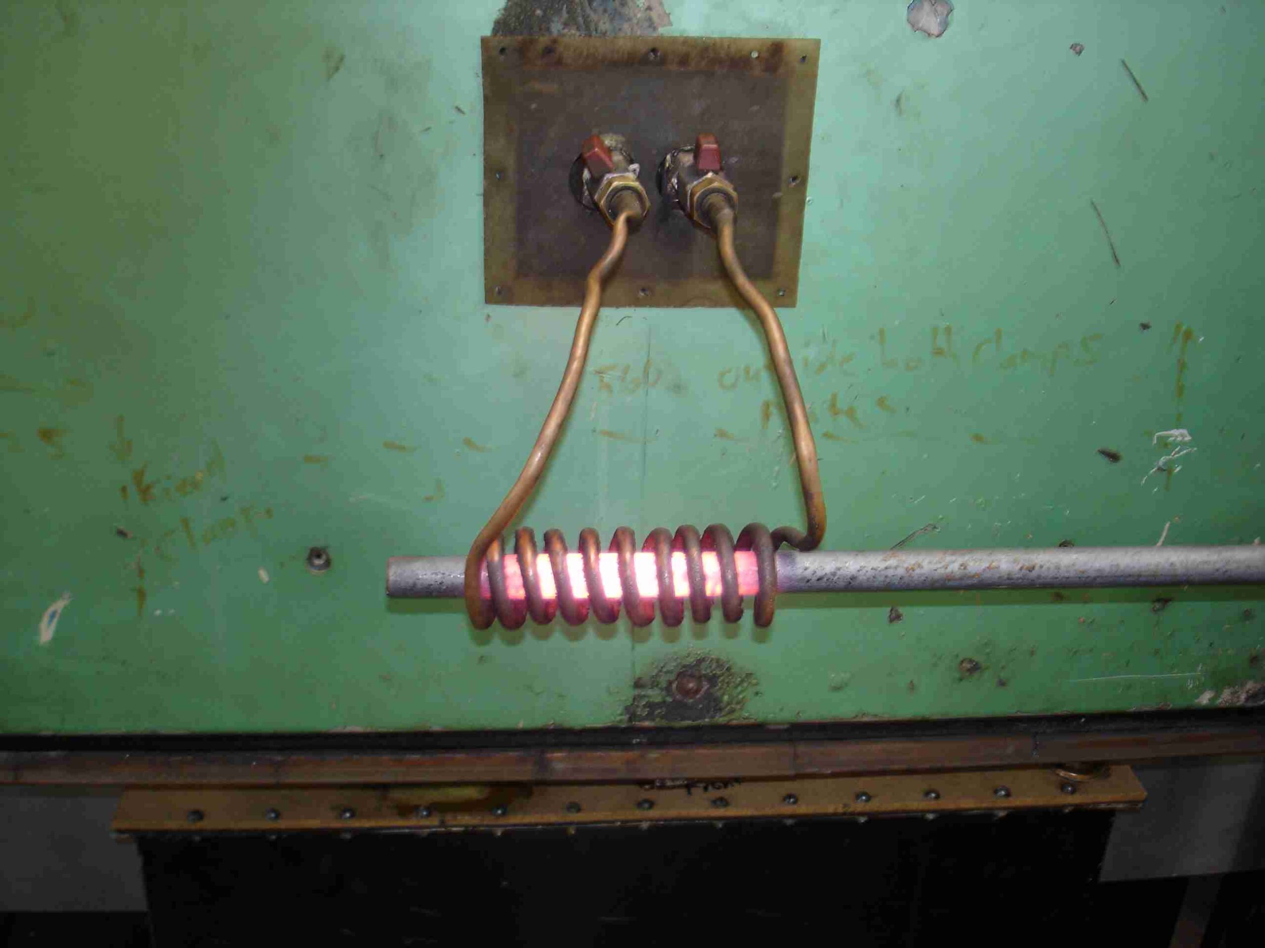 bobina de cobre de calentamiento por inducci&oacute;n poniendo al rojo vivo una barra de acero
