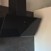 Campana extractora de cocina moderna instalada sobre la placa