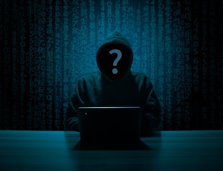 Hacker anónimo con sudadera y capucha frente a un portátil, con lluvia de código binario de fondo, representando el hacking ético y el bug bounty