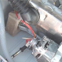 motor de una lavadora visto por dentro tras retirar la tapa trasera, con el cableado del sensor a la vista