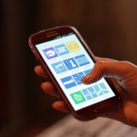Mano sujetando un smartphone con la pantalla encendida, un móvil que puede sobrecalentarse con el uso