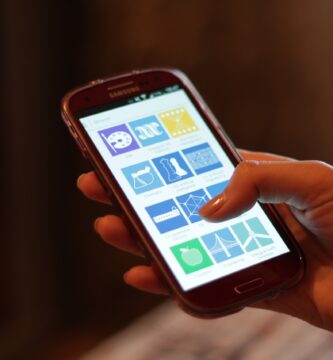 Mano sujetando un smartphone con la pantalla encendida, un móvil que puede sobrecalentarse con el uso