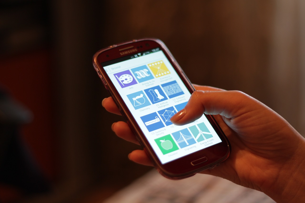 Mano sujetando un smartphone con la pantalla encendida, un m&oacute;vil que puede sobrecalentarse con el uso