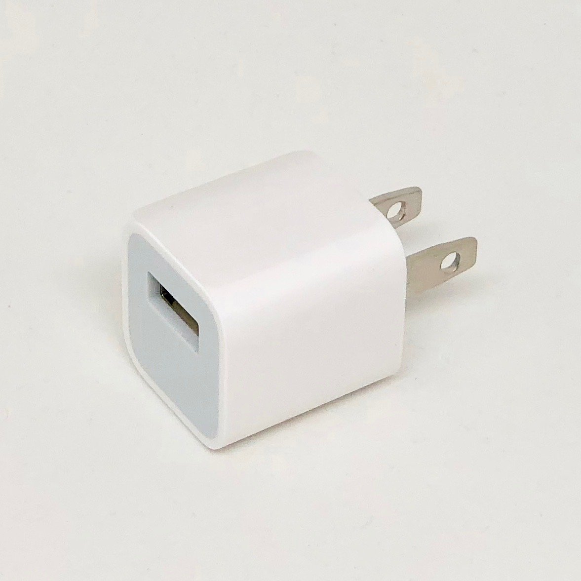 Cargador USB de m&oacute;vil blanco sobre fondo claro